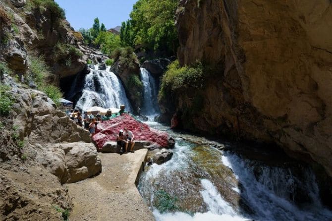 Cascading waterfall in Imlil surrounded by lush greenery and mountain rocks