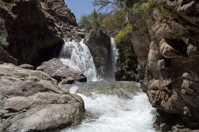 Cascading waterfall in Imlil surrounded by lush greenery and mountain rocks